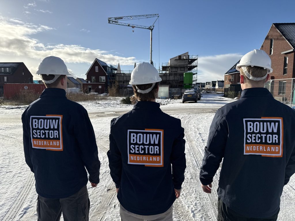 Drie collega's van Bouwsector Nederland met bouwhelm bij nieuwbouwwoningen in aanbouw